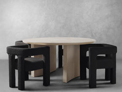 A round table surrounded by four chairs, including one distinct black chair among them