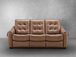 A tan leather reclining sofa is displayed, showcasing its elegant design and comfortable seating features