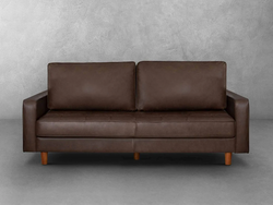 A brown leather couch positioned in front of a plain wall, creating a cozy and inviting living space