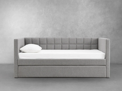 A grey daybed featuring a crisp white mattress, elegantly arranged for a cozy and inviting atmosphere