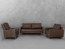 A brown leather sofa and chair set positioned elegantly in front of a textured wall, creating a cozy living space