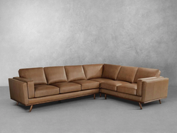 A modern tan leather sectional sofa displayed in a stylish living room setting, showcasing its sleek design and comfort