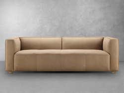 A modern tan leather sofa featuring elegant wooden legs, showcasing a blend of comfort and contemporary design